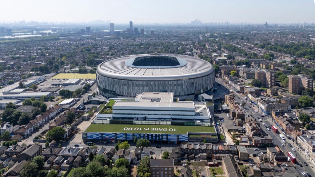 An aerial view of the Tottenham Hotspur Stadium amid the dense North London cityscape.