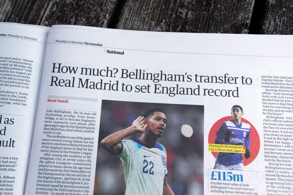 A newspaper article headlined 'How much? Bellingham's transfer to Real Madrid to set England record', citing a 115 million pound fee.